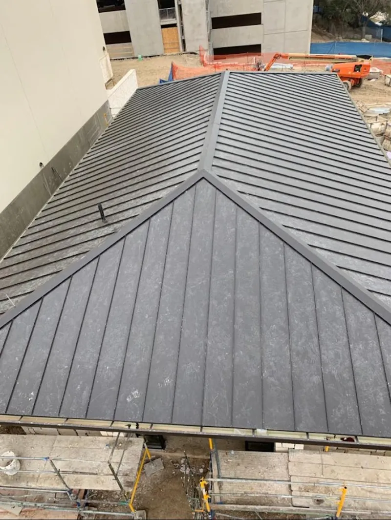 Commercial metal roof construction with crane equipment in Northridge